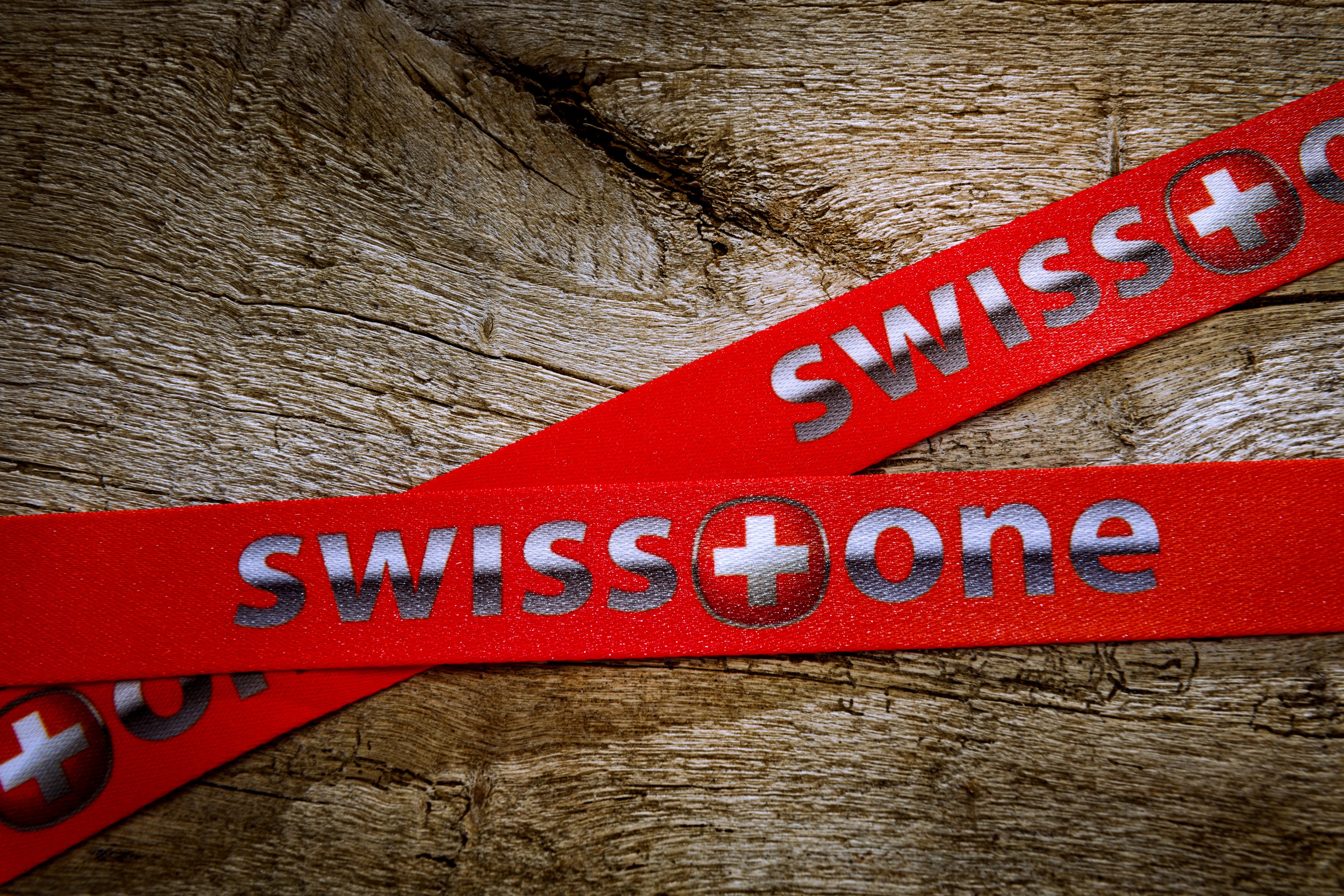 Schlüsselband aus Satin in roter Farbe mit Aufdruck auf Holzoberfläche