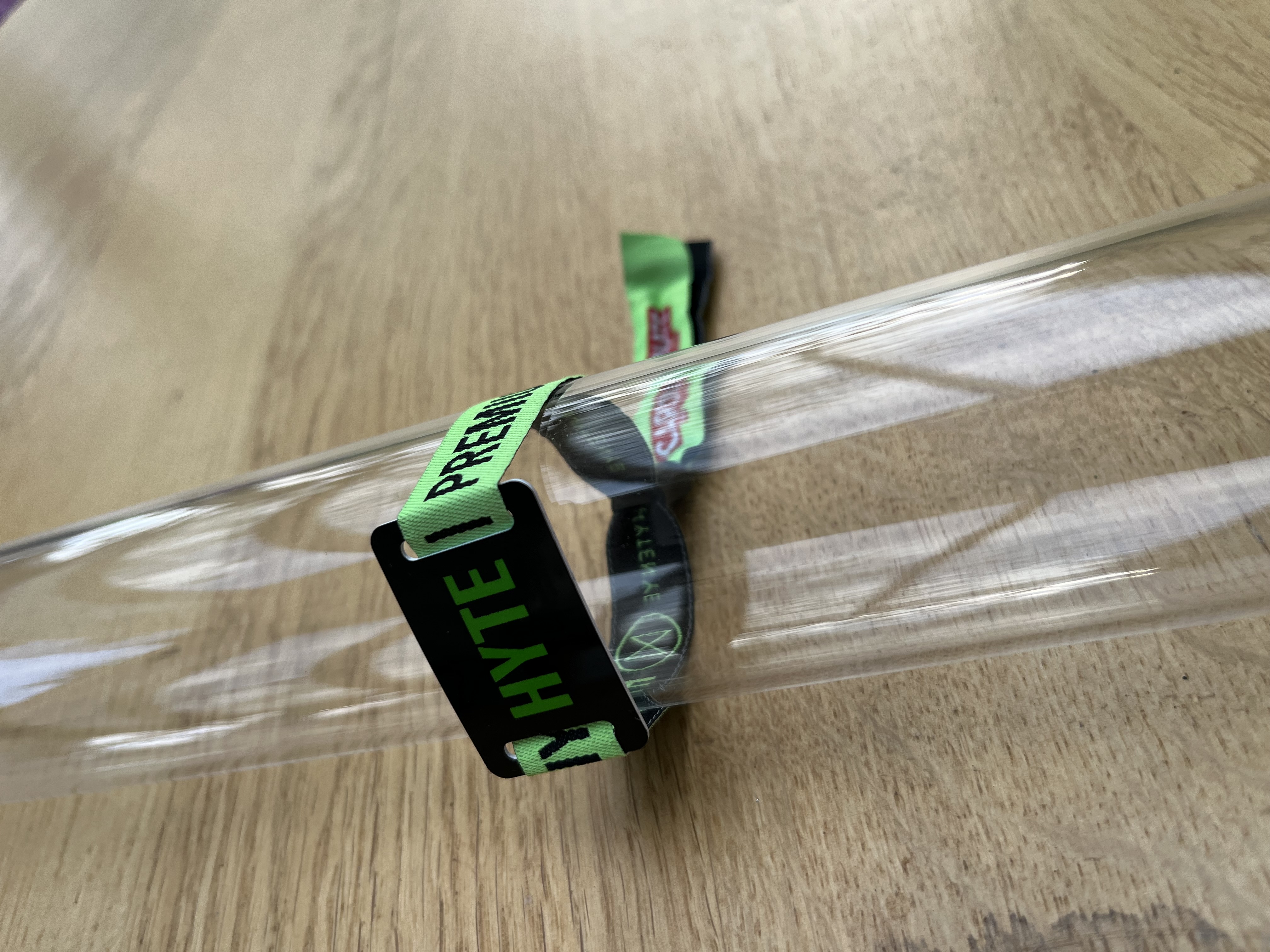 Festival-Armband mit grünem Text und RFID-Chip auf Holzoberfläche