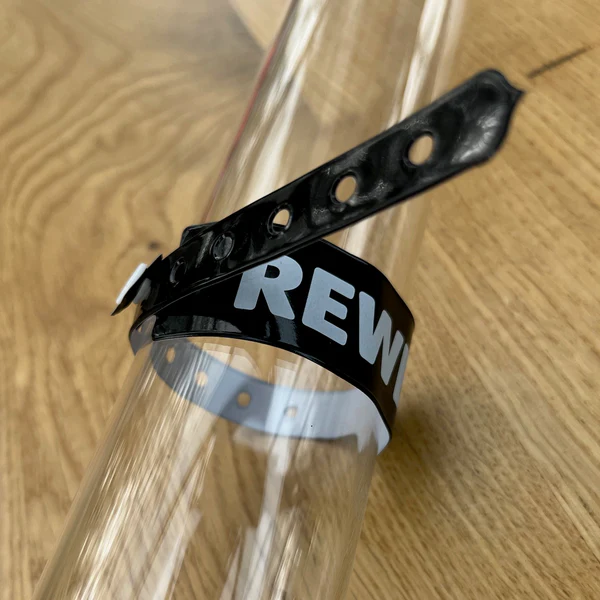 Schwarzes PVC-Einlassband mit Logo um einen Glaszylinder gewickelt