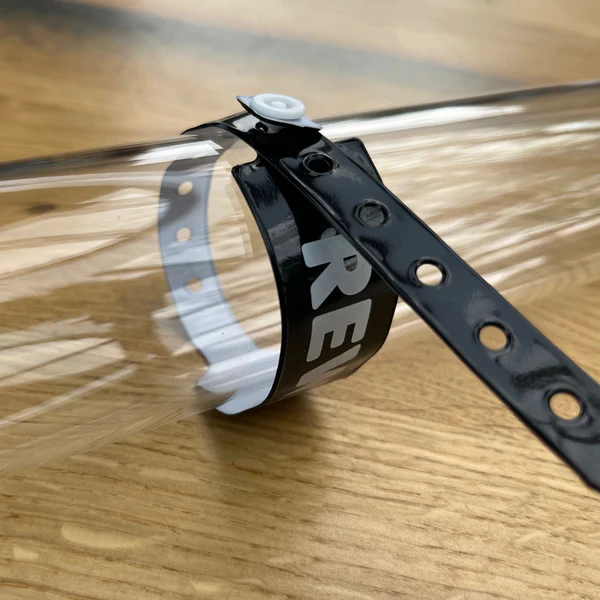Schwarzes PVC-Einlassband mit Logo um einen Glaszylinder gewickelt