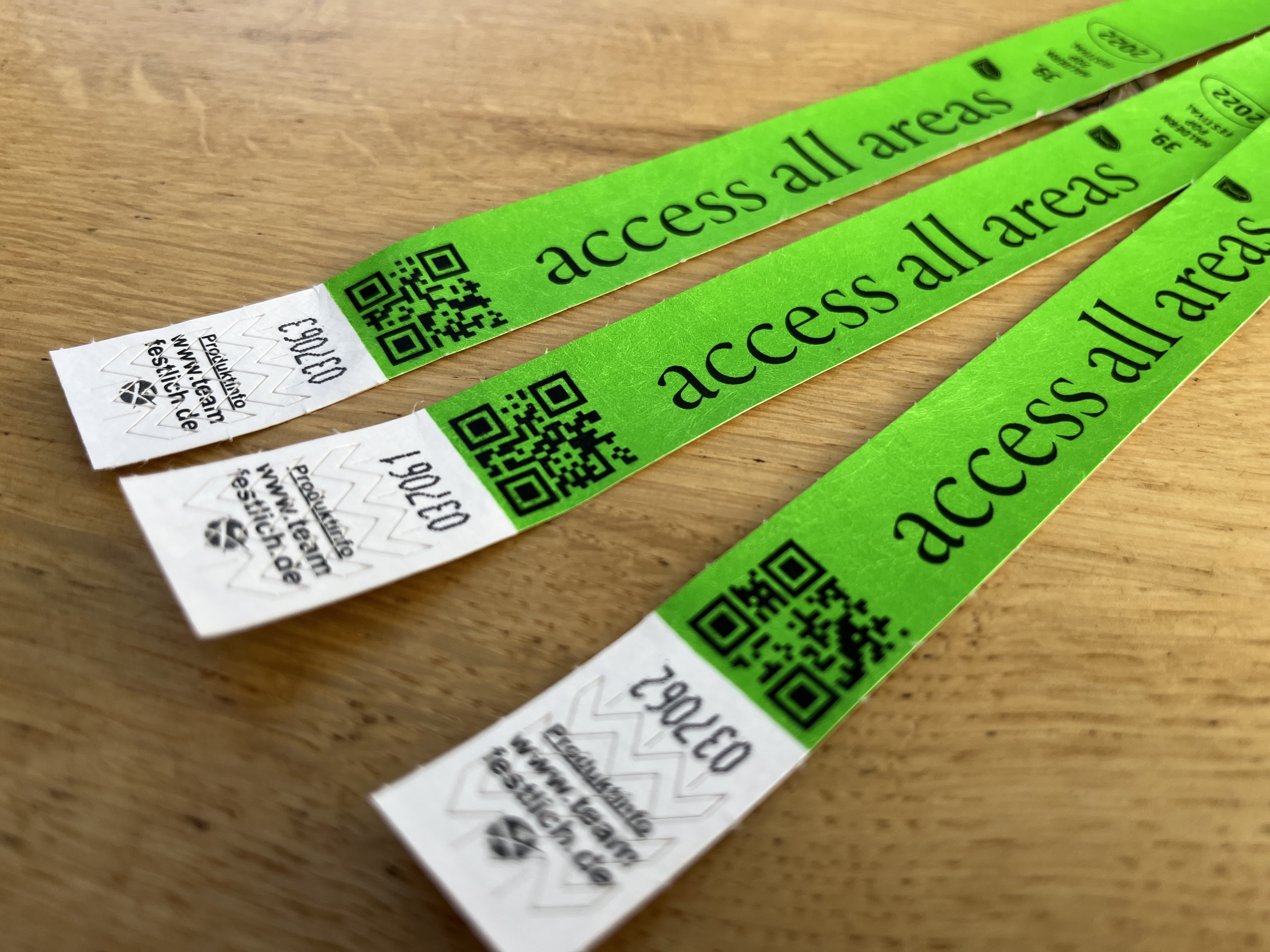 Leuchtend grüne Einlassbänder aus Tyvek mit QR-Codes und Zugangstext