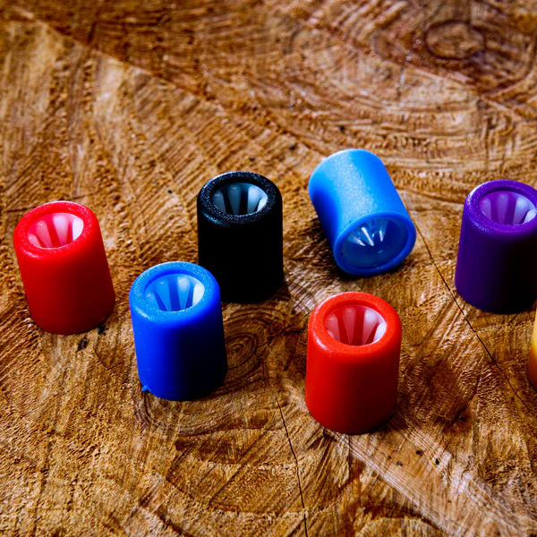 Mehrere zweiteilige Kunststoffverschlüsse in verschiedenen Farben auf Holzoberfläche