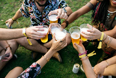 Gruppe von Festivalbesuchern mit Bier genießt die Musik