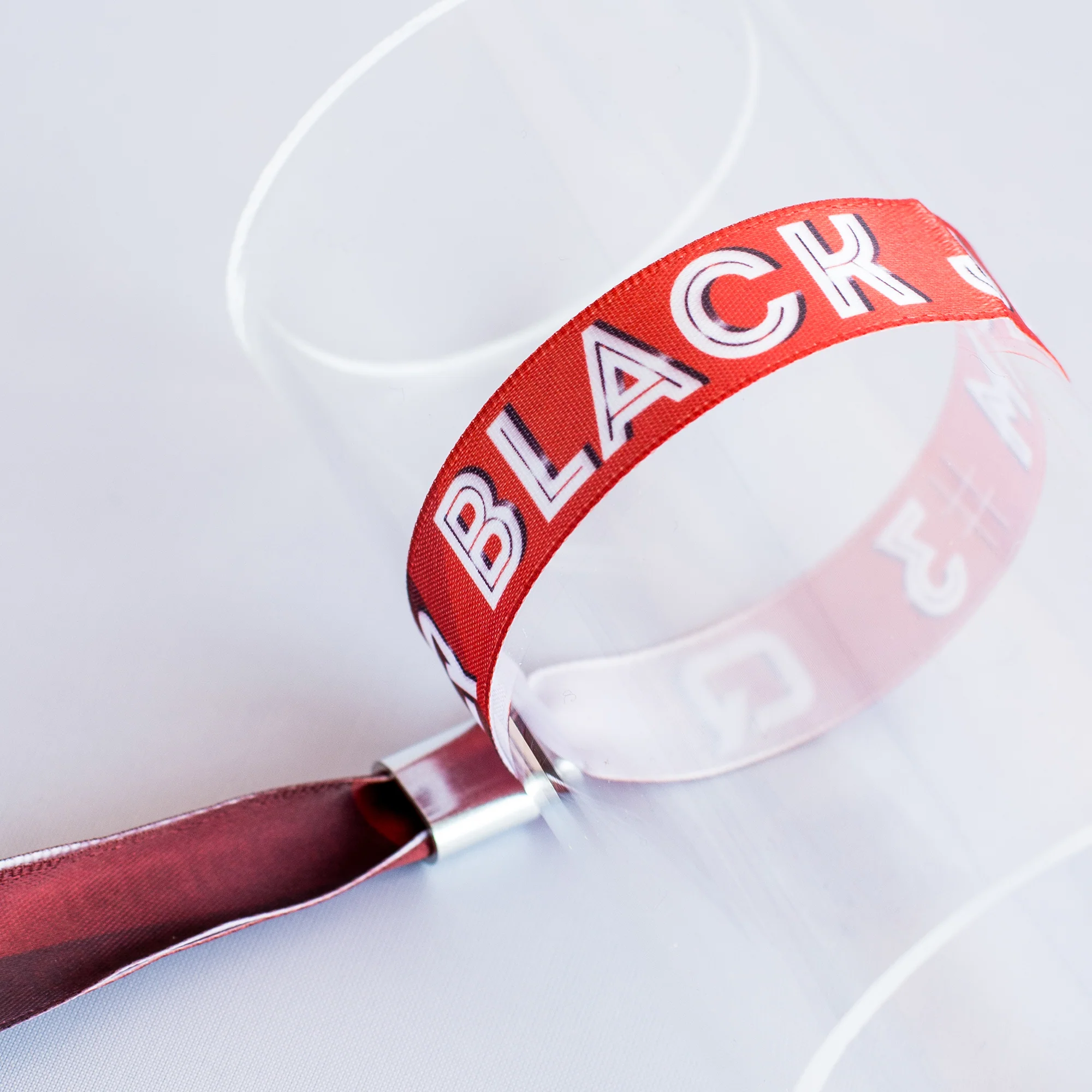 Rotes Stoff-Einlassband mit Metallverschluss auf Glaszylinder